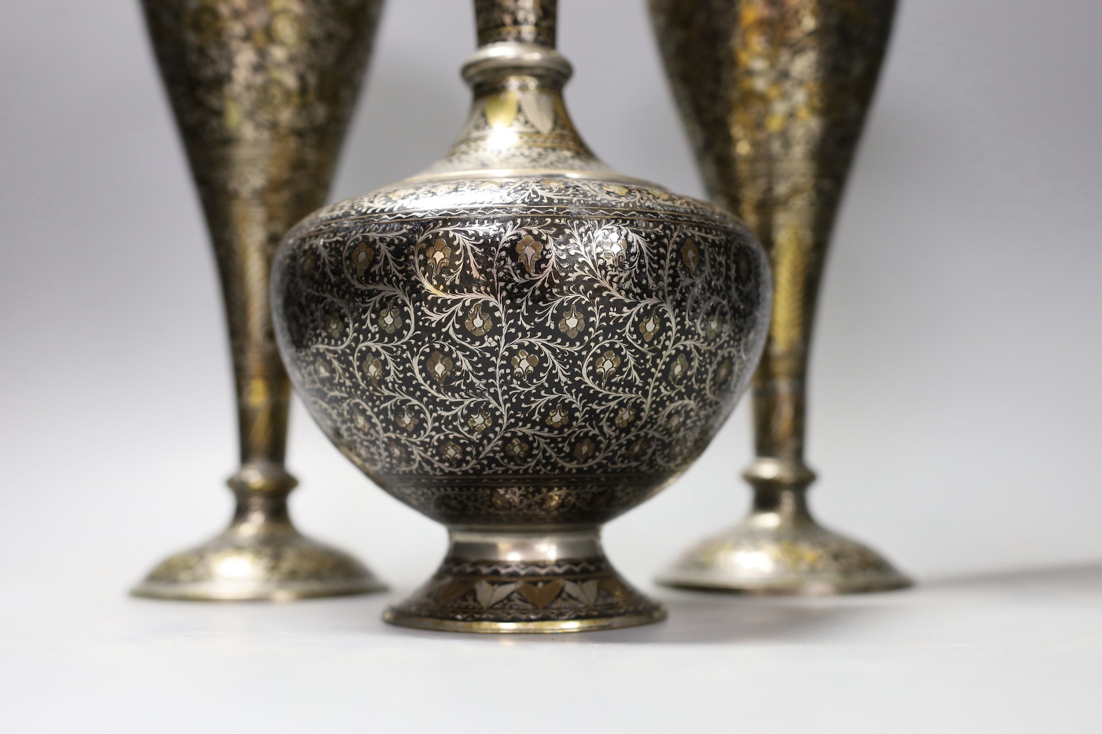 A pair of Indian damascened brass vases and a similar vase, pair of vases 33cms high